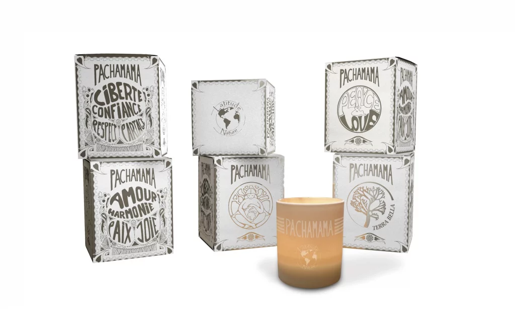 Gamme de bougie Pachamama de Latitude Nature montrant 6 boîtes l'une sur l'autre et l'une à côté de l'autre avec un verre bougie au milieu